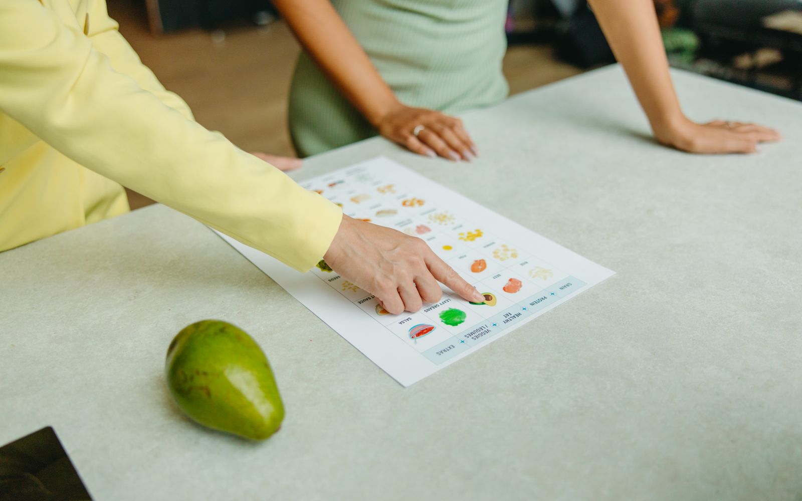 Two adults discussing food options with a nutrition chart